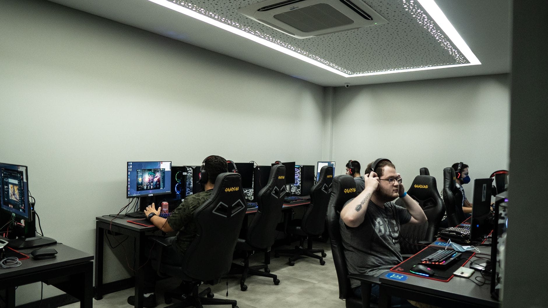 Grupa graczy przy komputerach w nowoczesnym centrum e-sportowym