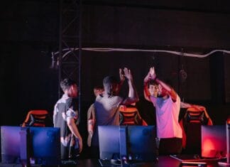 Młodzi gracze e-sportowi świętują zwycięstwo w ciemnym pokoju gamingowym