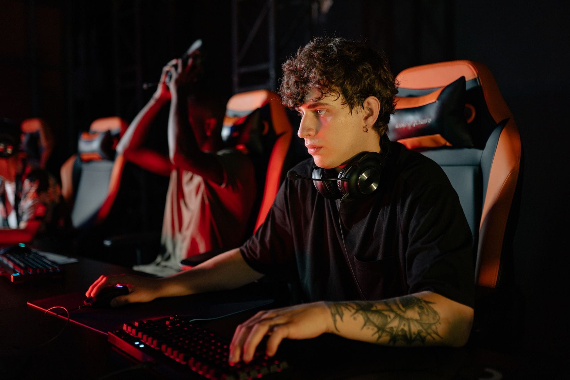 Zawodowi e-sportowcy skupieni przed monitorami na turnieju