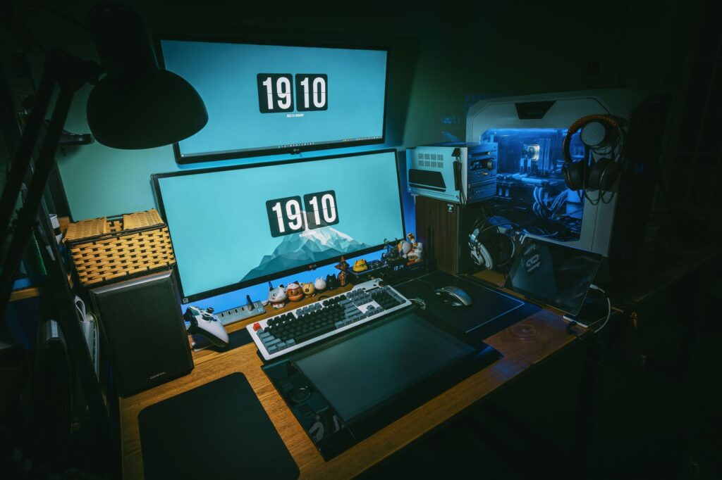 Stanowisko gamingowe z dwoma monitorami i komputerem PC w ciemnym biurze